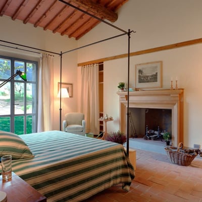 This spacious double bedrooms has an old stone fireplace and opens out onto the garden