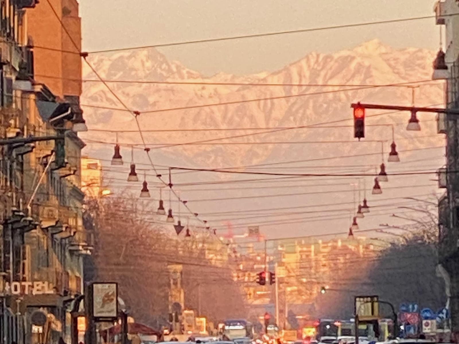 The Western Alps seen from Torino, looking up a wide city avenue in the morning